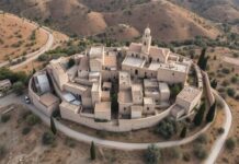 Taybeh Village Fire Israeli Attack Media Silence: The Burning of Ancient Christian Heritage Aerial view of Taybeh village showing its ancient architecture and surrounding olive groves with the West Bank landscape in the background
